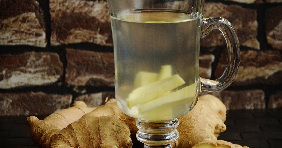 Cốc trà gừng nóng cùng vài lát gừng tươi